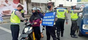 Di Kota Jayapura, Polisi Bagikan Masker dan Bendera Merah Putih