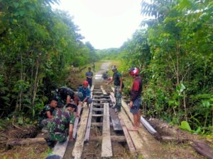Satgas Pamtas 312/KH Bersama Warga Perbaiki Jembatan Kampung Towe Hitam