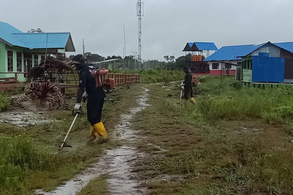 Personel Satgas TMMD 113 Mappi Kerja Bakti Bersihkan Areal Sekolah