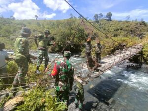 Personil TNI Bersama Masyarakat Kampung Dolinggame Perbaiki Jembatan Rusak