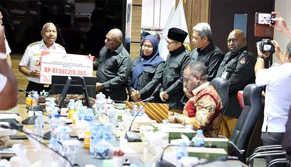 Ketua KPU Papua Barat Paskalis Semunya menyerahkan sisa dana hibah Pilkada serentak tahun 2024 kepada Gubernur Dominggus Mandacan di lantai 5 ruang rapat kantor Gubenur Papua Barat, Manokwari, Rabu (9/4/2025) / Foto : Ist
