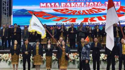 Ketua Umum K3MS Anneke Lieke Makatuuk,S.E.,M.M mengibarkan bendera Pataka organisasi setelah diserahkan oleh Wali Kota Sorong usai pelantikan di Gedung Lambert Jitmau, Kota Sorong, Rabu (25/3/2026) malam. Foto/ KENN